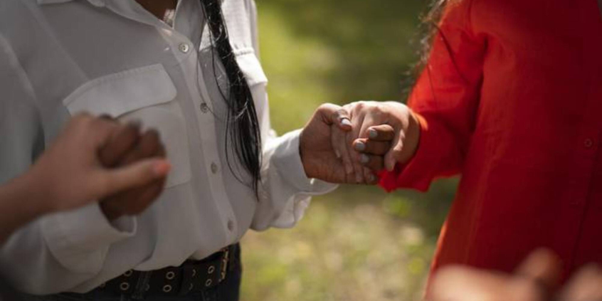 Pessoas em roda segurando as mãos
