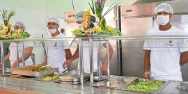 Funcionários uniformizados servem comida no Restaurante Popular do Barreiro, em Belo Horizonte