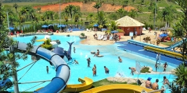 Vista superior do clube Lagoa Acqua Park. Área verde, toboáguas, piscinas, quiosques e diversas pessoas usando o espaço para lazer