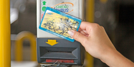 detalhe de uma mão segurando o cartão bhbus em frente ao sensor, na catraca do ônibus