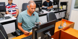 O vereador Wagner Ferreira fala ao microfone e olha para a tela do computador.