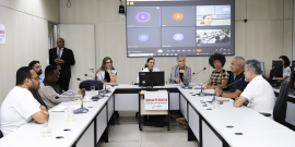 Foto de reunião conjunta. Vereadores estão sentados à mesa com um telão na parte de trás.