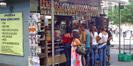 Banca de jornal com clientes aguardando atendimento