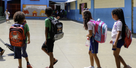 Crianças em idade escolar com mochilas nas costas