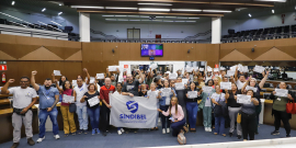 Agentes de saúde exibem cartazes com frases de ordem