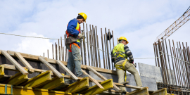 Dois homens vestindo equipamentos de segurança em obra de construção civil