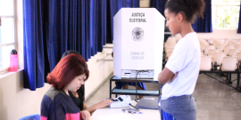 Cabine de voto da Câmara Mirim; adolescente está em frente à mesária
