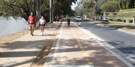 trecho da avenida Otacílio Negrão de Lima, na orla da Lagoa da Pampulha, mostrando pedestres, motoristas e ciclistas
