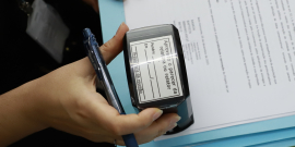 Mão segurando carimbo em cima de documento