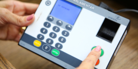 Mãos de parlamentar registrando voto em reunião plenária