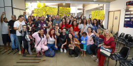 Presentes na audiência pública posam para foto e erguem cartazes
