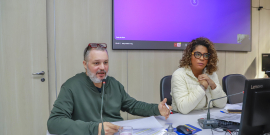 Pedro Patrus fala ao microfone com Juhlia Santos ao seu lado no Plenário Helvécio Arantes