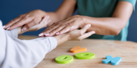 duas pessoas encostas as mãos sobre a mesa