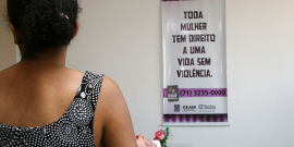 mulher de costas em frente a um cartaz