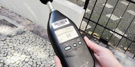 mãos segurando um aparelho medidor de nível sonoro