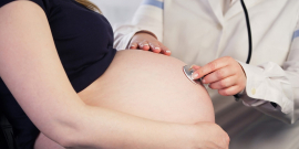 profissional de saúde ausculta barriga de mulher grávida