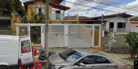 Fachada de uma casa com portão na frente, onde funciona casa de acolhimento