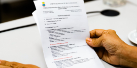 mãos de parlamentar seguram documento de comissão