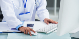 Mãos de médico usando computador enquanto trabalha