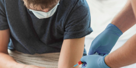 profissional de saúde realiza coleta de sangue em homem jovem