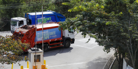 caminhões de coleta de lixo trafegando em via pública
