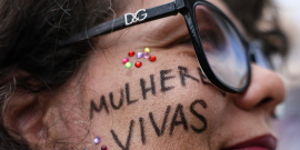 rosto de mulher com a expressão mulheres vivas pintada de preto na altura da bochecha