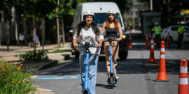 duas mulheres andando de patinete