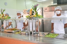 Funcionários uniformizados servem comida no Restaurante Popular do Barreiro, em Belo Horizonte