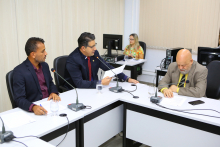 Três vereadores estão assentados à Mesa apreciando a pauta da reunião