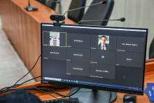 Dois homens participam de reunião remota, exibida em tela de computador.