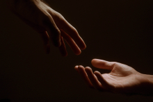 Foto mostra duas mãos se aproximando 