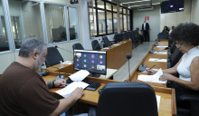 Dois parlamentares em reunião, sentados à mesa.