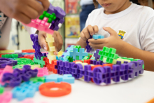 Criança mexe com brinquedo de montar em sala de aula