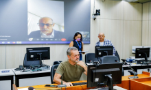 Vereador Wilsinho da Tabu sentado em frente ao computado, com a tela atrás projetando a imagem do vereador Fernando Luiz.