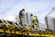 Dois homens vestindo equipamentos de segurança em obra de construção civil