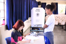 Cabine de voto da Câmara Mirim; adolescente está em frente à mesária