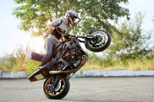 Motociclista pilota apoiado apenas na roda traseira