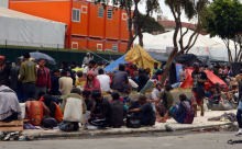 pessoas em situação de rua sentadas juntas e aglomeradas