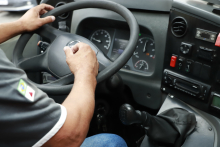 close nas mãos de motorista segurando voltante de automóvel