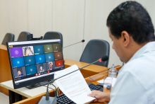 Vereador presidente da reunião conjunta em frente a tela com demais vereadores para apreciar parecer