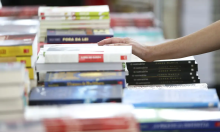 livros didáticos infantis empilhados e dispostos sobre uma mesa