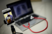 Celular conectado a médico, em primeiro plano