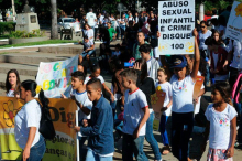 crianças fazem protesto contra abuso infantil levando cartazes