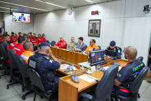 Representantes de instituições e brigadistas profissionais reunidos ao redor de mesa durante audiência