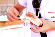 profissional de saúde manuseia modelo de arcada dentária