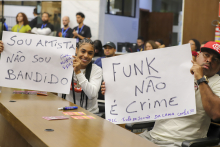 participantes de audiência pública na câmara de bh segurando cartazes