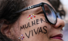 rosto de mulher com a expressão mulheres vivas pintada de preto na altura da bochecha